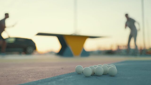 People playing table tennis outdoors at sunset