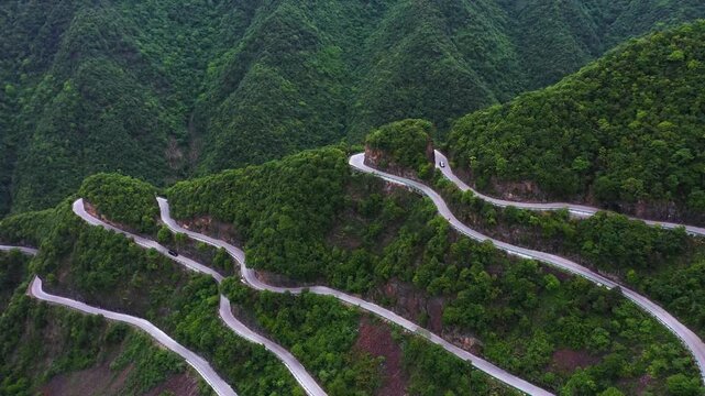 Vehicle Navigating Steep Switchbacks on a Scenic Mountain Pass Road