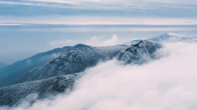 Aerial View of Snow-Capped Mountain Peaks Emerging Above a Vast Cloud Sea