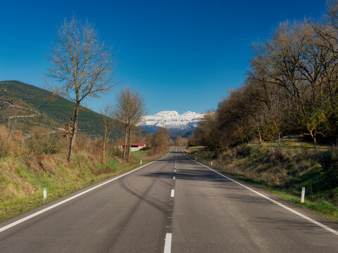 Road in Aragon, Spain with snowy mountains in the background