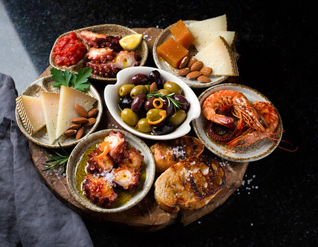 45-degree angle view of Spanish tapas variety presented in a vibrant flat lay arrangement.