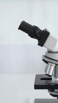 A microscope stands on a laboratory table, ready for groundbreaking medical research in sterile conditions. A concept of medicine and science