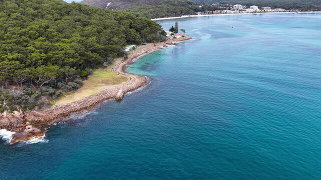 Aerial drone video panning around Tomaree Mountain in Port Stephens, New South Wales, Australia showing World War II torpedo and gun emplacement positioned on rugged coastal headland.