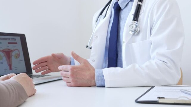 Doctor reviewing digital test results with patient, discussing health findings on laptop screen during clinical consultation. Medicine and health care concept.