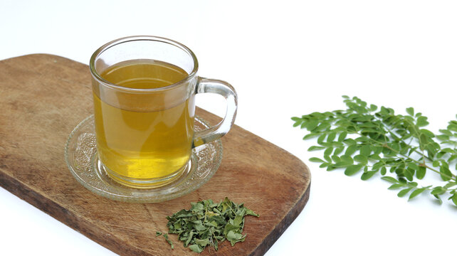 Moringa or Daun kelor herbal drink. A cup of Moringa tea. Boiled moringa leaves water in cup on white background. Healthy drink lifestyle