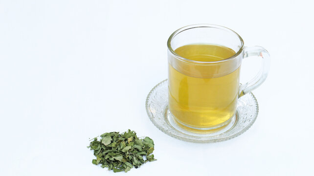 Moringa or Daun kelor herbal drink. A cup of Moringa tea. Boiled moringa leaves water in cup on white background. Healthy drink lifestyle