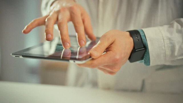 Doctor's hands hold an electronic tablet, zooming into panoramic x-ray on the screen. In the clinical setting, the medical professional examines details to locate problem areas, using healthcare tech