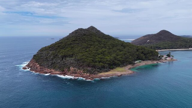 Aerial drone video panning around World War II torpedo and gun emplacements at Tomaree Head in Port Stephens, New South Wales, Australia. Scenic coastal landscape featuring historic military structure