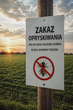 Agricultural warning sign (Polish language) in a rural field at sunset announces restricted pesticide spraying to protect pollinators, highlighting environmental stewardship, sustainable farming, bee 