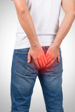 Man suffering from hemorrhoids or anal pain touching his backside with red highlighted area, digestive problem concept