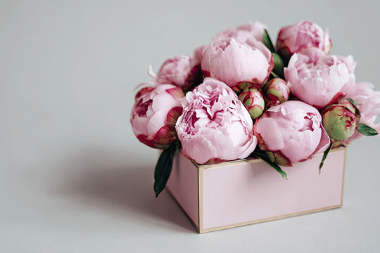 Beautiful gift box with pink peonies. Concept of internet shopping, flower shop. Flowers composition for Valentine's, Mothers or Women's Day 