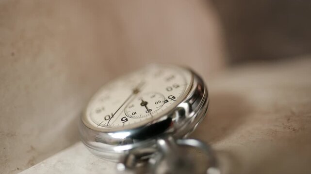Cinematic vintage aged notebook page with a stopwatch on top, its hands. management and business concepts. vintage composition focused on time and productivity. A classic old stopwatch  