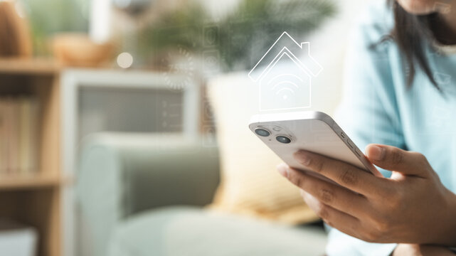 Smart home concept with mobile control interface, representing IoT automation, wireless connectivity, energy efficiency, and secure digital home management for modern lifestyle and connected living.