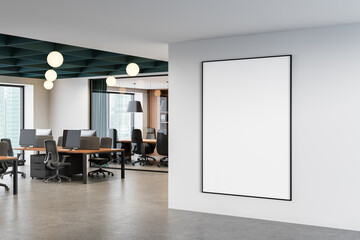 Modern office interior showcasing open workspace layout with desks and chairs beside a white wall...