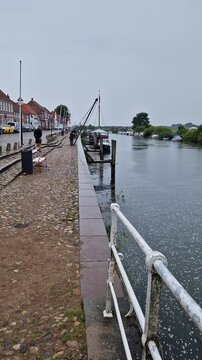 Ribe Harbor Waterfront Walk with River View and Moored Vessel, Ribe, Denmark