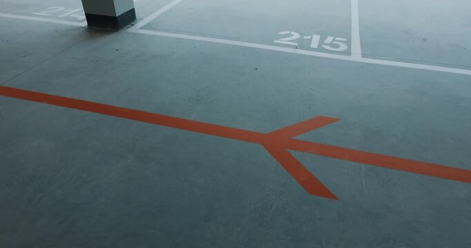 Directional marking arrow on parking floor with numbered space lines close up