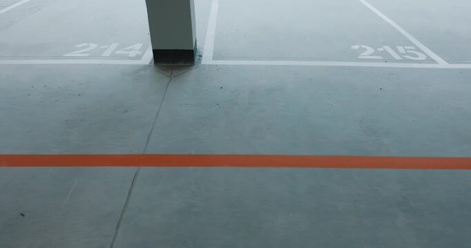 Directional marking arrow on parking floor with numbered space lines close up