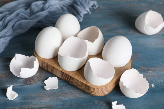 Holder with egg shells on blue wooden table