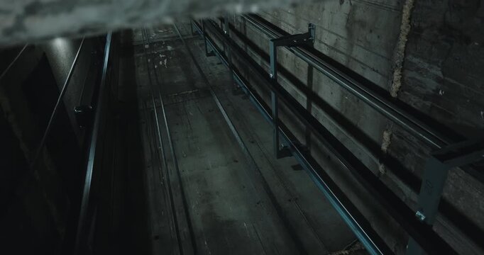 View up elevator shaft with cables and guide rails perspective