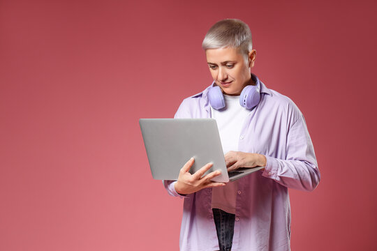 Female programmer working with laptop on red background