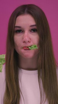 Young teen girl eating lettuce leaves, fresh healthy salad. Woman enjoying healthy food and clean eating lifestyle. Female have a organic vegetables, vegetarian diet concept, wellness, nutrition,