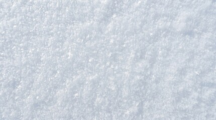 Obraz premium Snow texture covers the ground in a uniform layer of white crystalline ice crystals that sparkle under the bright winter daylight.