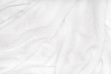 Fototapeta premium soft white blanket is spread out on a flat surface, its soft texture visible through it. It lies comfortably and feels warm.