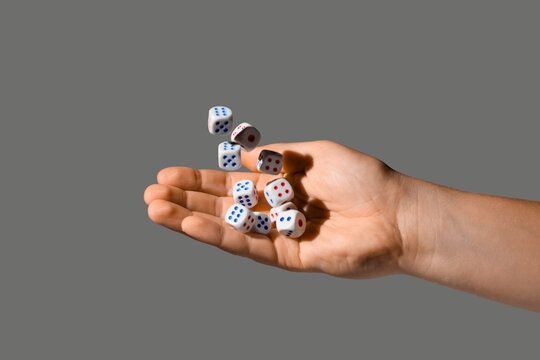 Male hand throwing game dices on grey background, closeup