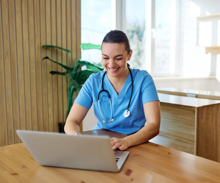 Portrait of a young nurse getting ready for work and using laptop online meeting at home. Overworked, busy, stress, urgency, multitasking concepts