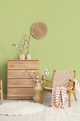 Obraz premium Wicker armchair, chest of drawers and vases with cotton flowers in interior of living room