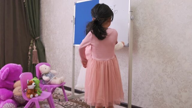 Little girl acts as strict teacher during play school game, standing with hands on hips and scolding another child, expressing discipline, behavior correction, childhood role play and education