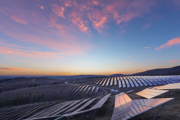 Fototapeta premium Solar Power Plant on Hillside Under Colorful Morning Sky