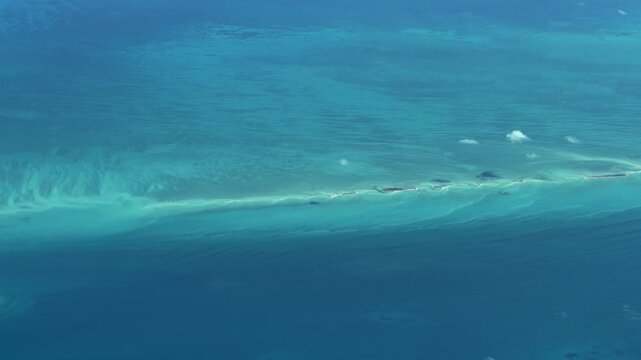 flying across turquoise water surface and a small atolls in The Bahamas, located in the Caribbean Sea in Atlantic Ocean - 4k aerial video footage 