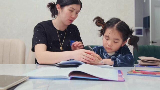 Asian girl stubbornly doing homework while mother supervises, child distracted and resisting guidance, challenging learning moment, discipline issues, home education struggle, concentration difficulty