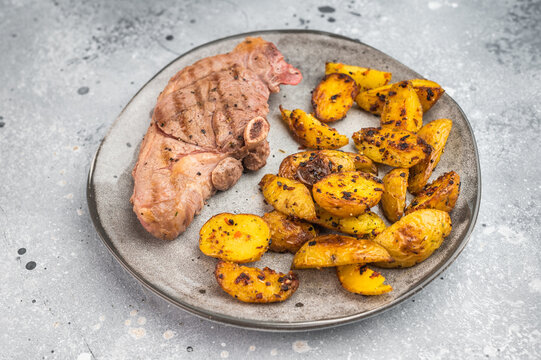 BBQ grilled lamb saddle steak with crispy baked potatoes, juicy bone in meat portion styled for modern culinary photography, top view composition.