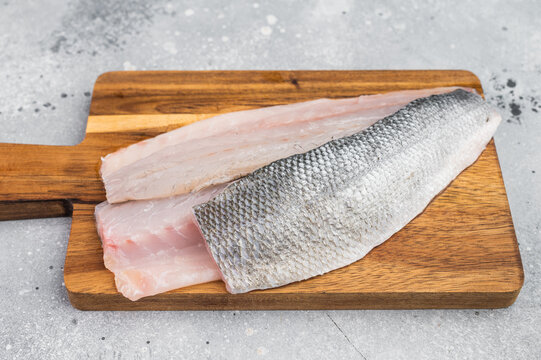 Fresh sea bass or branzino fillet portions with skin, gourmet marine seafood concept highlighting natural texture and healthy cooking preparation.