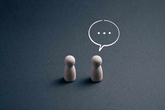 Silent communication between two people with speech bubble pause