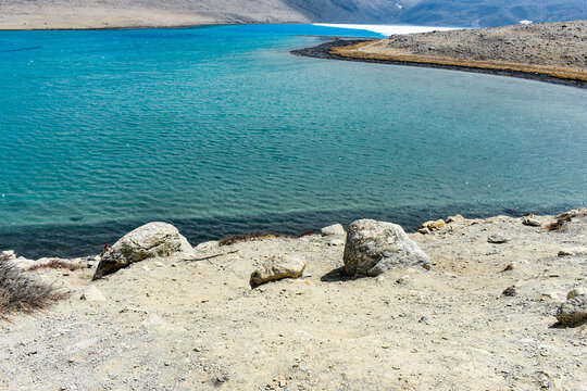 Remote Gurudongmar Lake, North Sikkim, India, featuring clear turquoise waters and stark high-altitude Himalayan scenery.