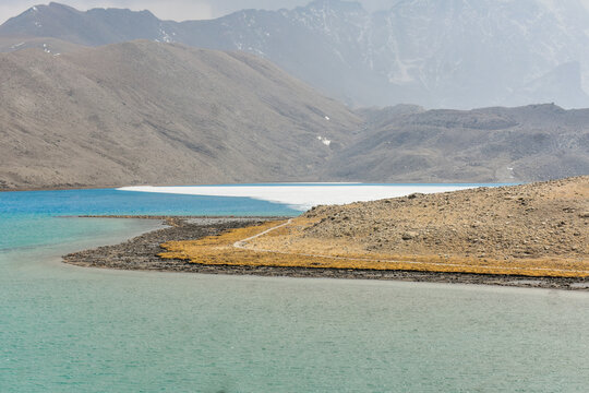 Gurudongmar Lake, North Sikkim, India, a pristine alpine lake with turquoise hues surrounded by rugged Himalayan slopes.