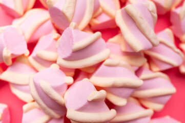 Fototapeta premium Marshmallow close-up on pink background, top view. Sweet sugar candies, abstract background. Marshmallow pattern. Sweet dessert texture