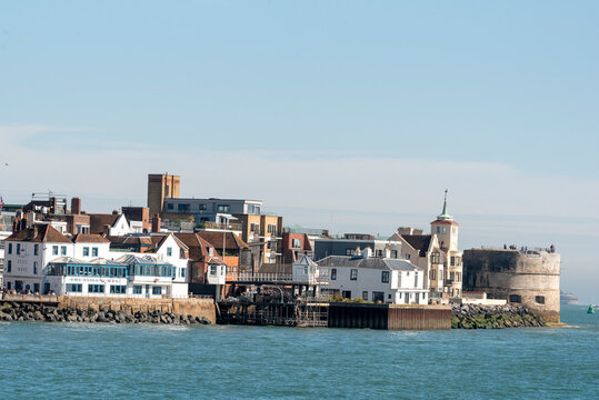 Old Portsmouth England UK. 25.04.2026. A scenic view of a historic seaside town featuring a prominent round tower, traditional houses, and contemporary architecture along the waterfront