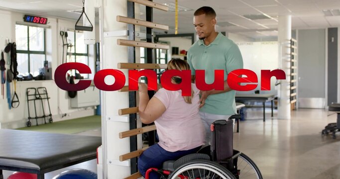 Gripping stall-bar, woman in wheelchair wearing pink shirt receiving hands-on guidance at rehab gym