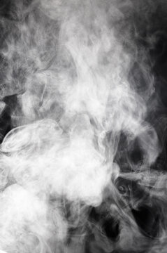 Abstract swirling white smoke against a dark background, creating ethereal patterns