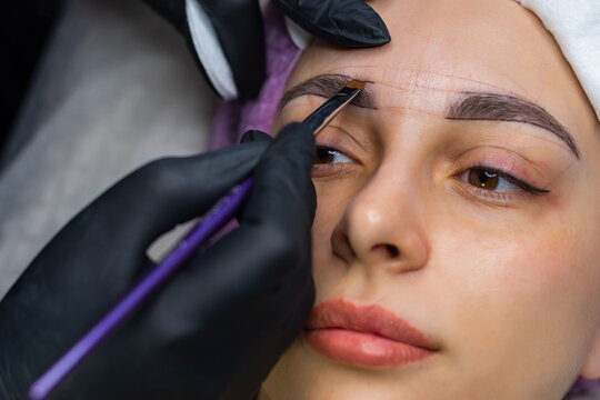 Close up of eyebrow shaping and mapping before permanent makeup, beautician marking brow symmetry in beauty salon