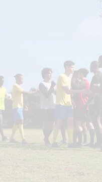 Vertical video: Yellow player stepping showing icons while soccer teams exchanging pats postgame