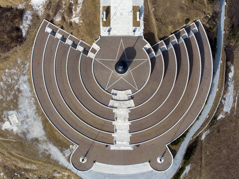 Aerial view of the Military Memorial of Monte Grappa with its concentric stone tiers and central star pattern in Pieve del Grappa, Veneto, Italy.