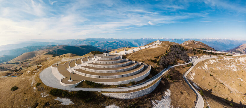 Aerial view of the Monte Grappa Military Memorial with its circular stone terraces on the mountain summit overlooking the alpine landscape in Pieve del Grappa, Veneto, Italy.
