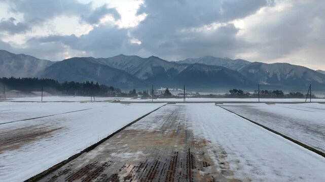 Aerial view of traditional Japanese mountain village with red roofs in winter snow, Fukushima