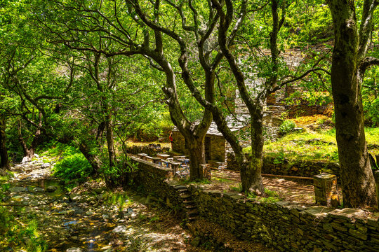 Old watermill building of Aris by river at fishing coastal village of Karavostamo on Ikaria island, Greece with stone fence