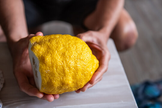 Amalfi lemon sfusato amalfitano citrus fruit originally from Italy grown on Ikaria island Greece longevity blue zone hand holding macro closeup